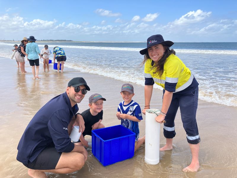 CN staff member Eliza Hoyland and UoN PHD student, Hayden Swift stand alongside young participants of CN's environmental event 'Hidden Life of Sand'.