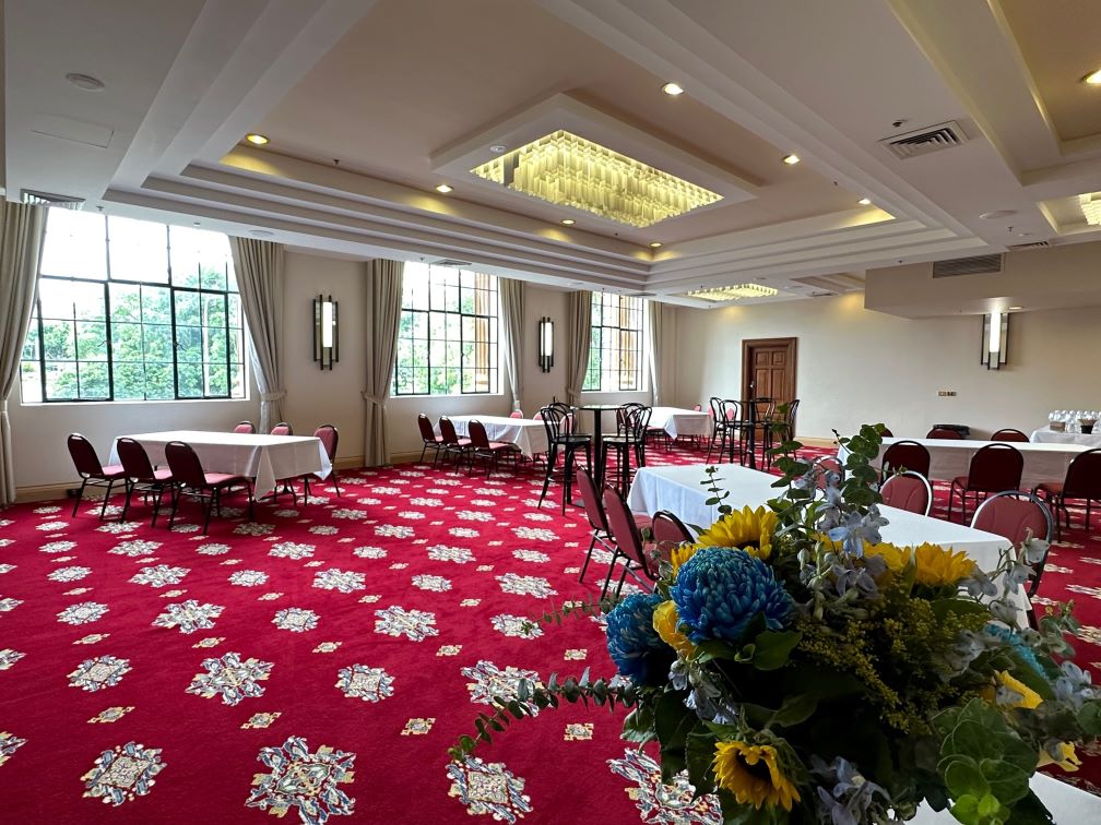 Mulubinba Room at Newcastle City Hall set up with long tables and chairs for a corporate function.